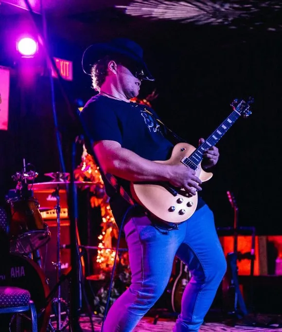 Dylan Cole performing a guitar solo at a live show.